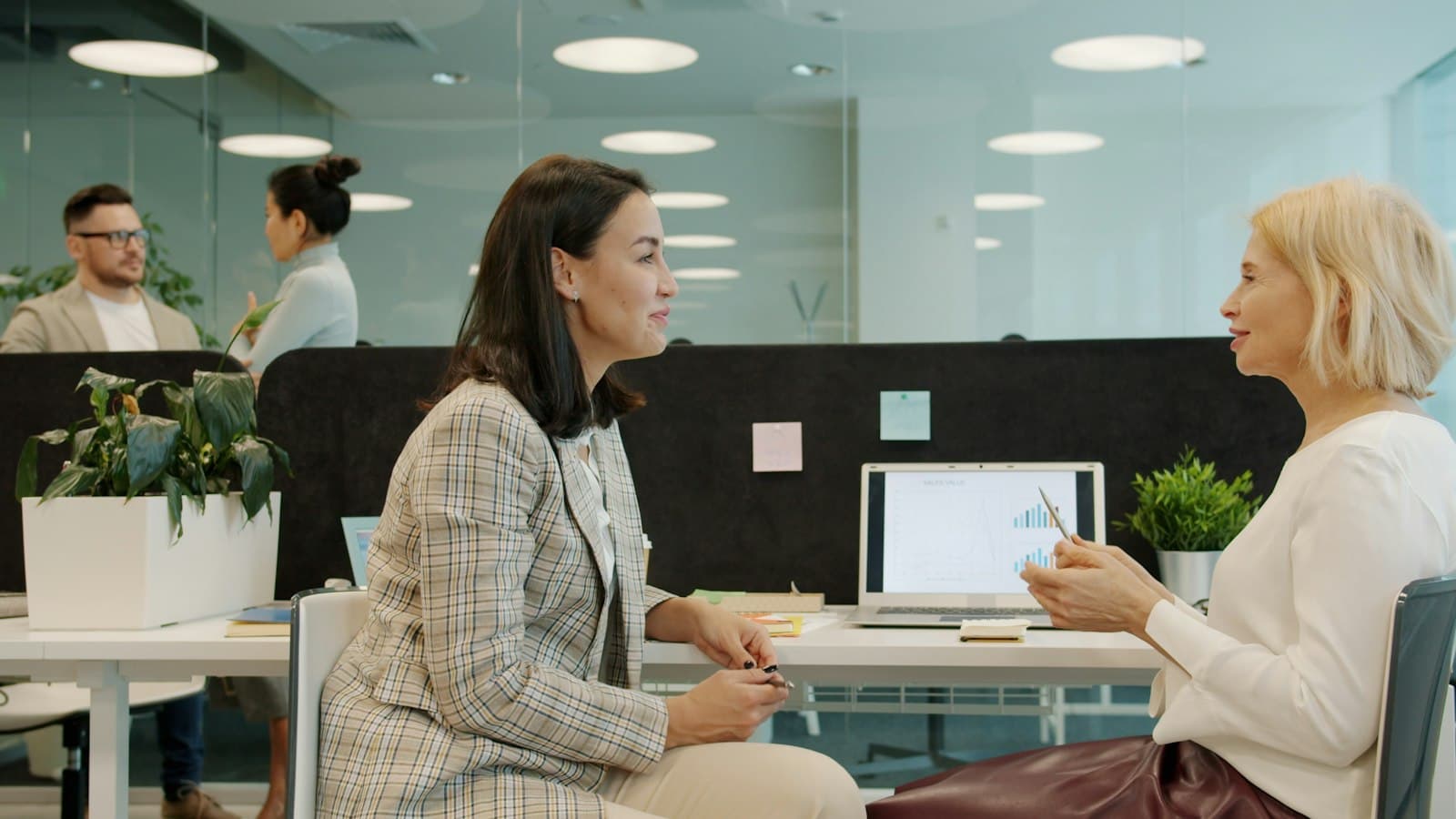Two professionals discussing a hiring brief at a desk in a modern office